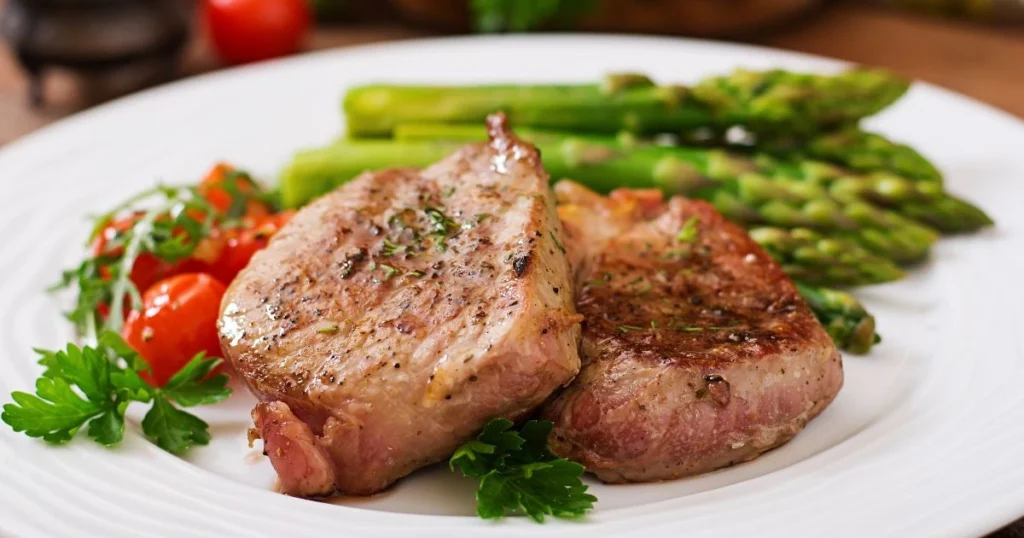 A succulent lamb breast plate, glistening with crisp, golden-brown skin, rests on a rustic wooden cutting board. The meat is perfectly seared, with a hint of charred edges that give way to tender, juicy flesh. Wisps of fragrant smoke curl upwards, hinting at the aromatic herbs and seasonings that have infused the lamb. Warm, directional lighting casts dramatic shadows, accentuating the plate's textural details. The scene is set against a simple, neutral background, allowing the star of the dish to take center stage. This mouthwatering image captures the essence of a delectable, home-cooked lamb breast plate, ready to be savored. Lamb Breast Plate Recipe